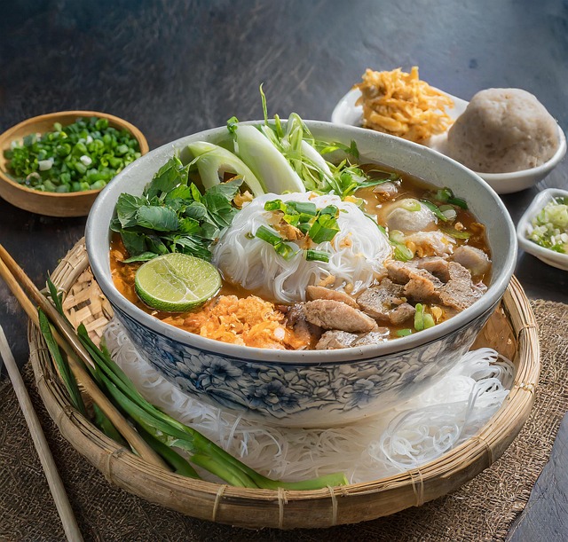 "हर्ब्स, अंडा, नींबू और हरे मसालों से सजी स्वादिष्ट वियतनामी नूडल सूप की हेल्दी बाउल – पारंपरिक एशियाई व्यंजन"